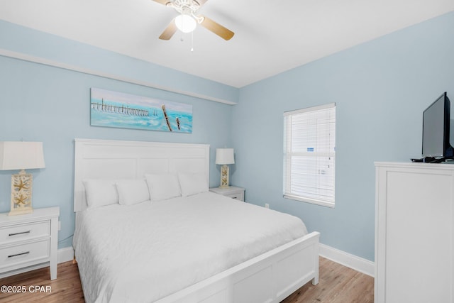 bedroom with a ceiling fan, baseboards, and wood finished floors