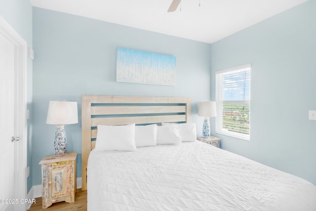 bedroom featuring a ceiling fan, wood finished floors, and baseboards