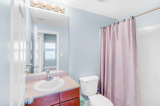 bathroom featuring curtained shower, toilet, vanity, and visible vents