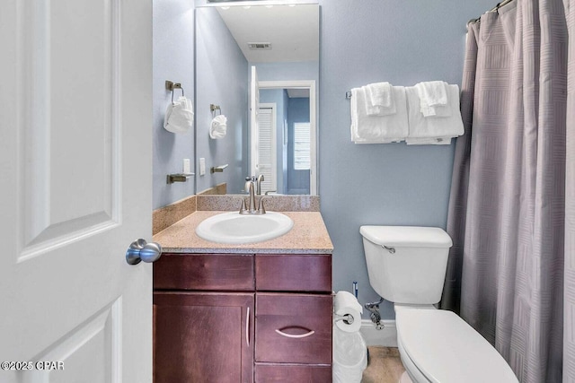 full bath with vanity, toilet, and visible vents