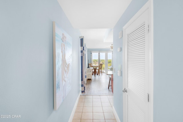 hallway with light tile patterned floors and baseboards