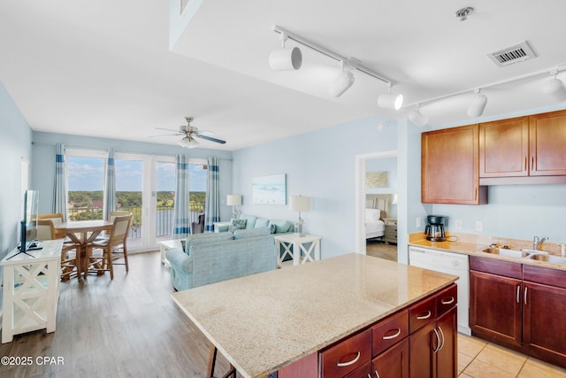 kitchen with visible vents, ceiling fan, a sink, dishwasher, and a center island