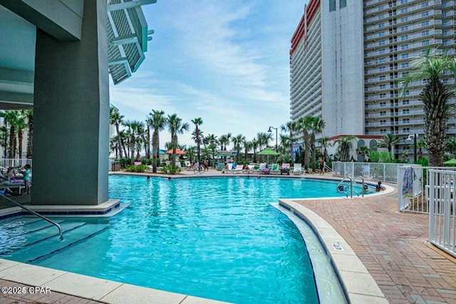 community pool featuring a patio and fence