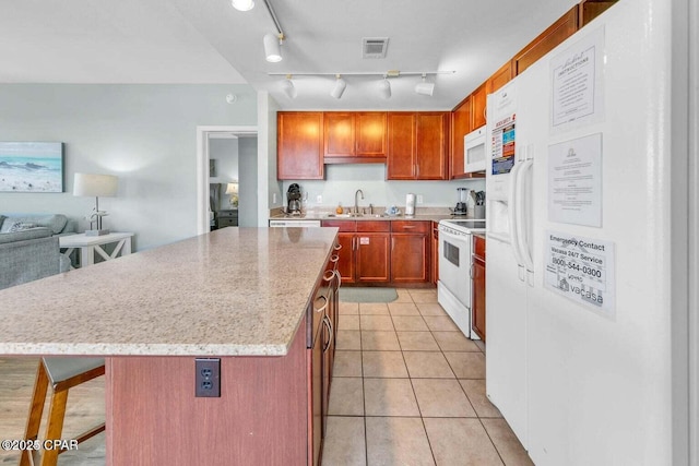 kitchen with white appliances, light tile patterned floors, visible vents, a sink, and a center island