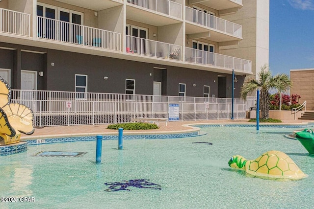 view of community with a pool and fence