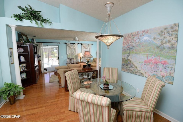 dining space with lofted ceiling, a ceiling fan, light wood-type flooring, and a textured ceiling