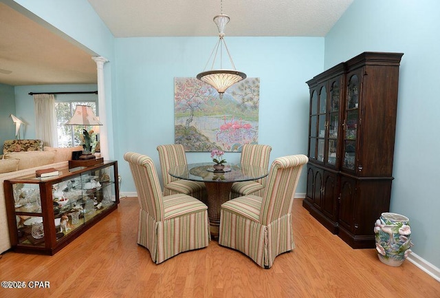 dining area with baseboards and wood finished floors