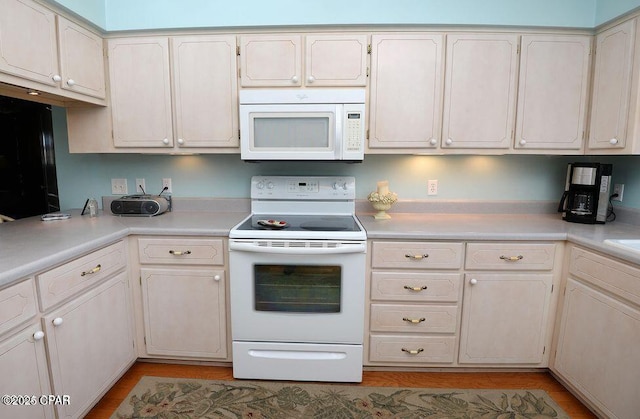 kitchen featuring light wood finished floors, white appliances, and light countertops