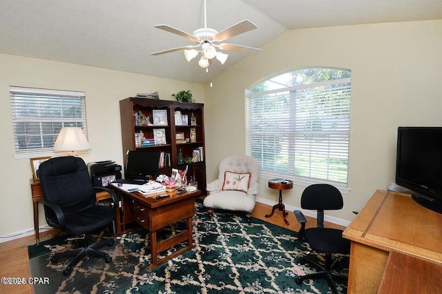 office area featuring vaulted ceiling, wood finished floors, baseboards, and ceiling fan