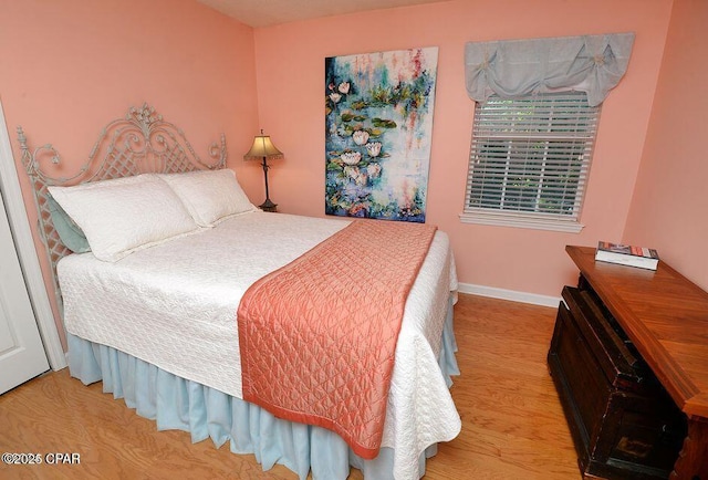 bedroom featuring baseboards and wood finished floors