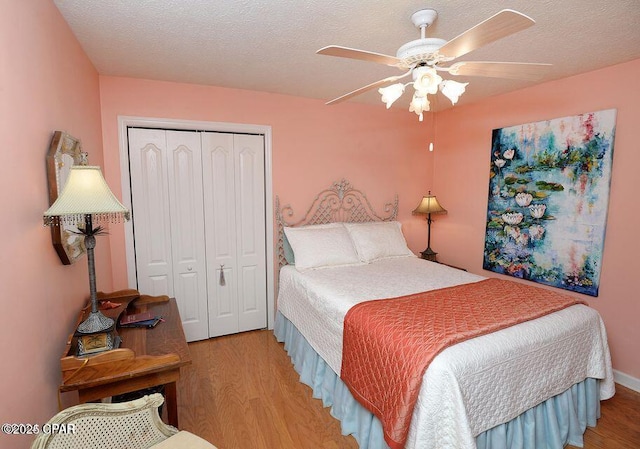 bedroom featuring ceiling fan, wood finished floors, a closet, and a textured ceiling