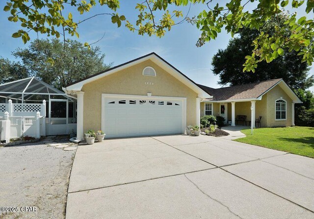 ranch-style home featuring stucco siding, a front lawn, driveway, fence, and an attached garage