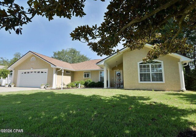 ranch-style home with stucco siding, concrete driveway, a front lawn, and a garage