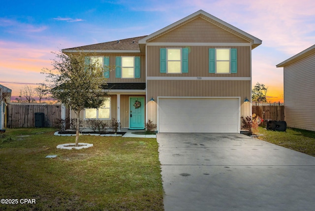 traditional-style house featuring a yard, fence, a garage, and driveway