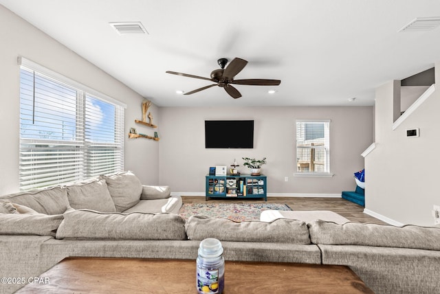 living area with visible vents, baseboards, ceiling fan, and wood finished floors