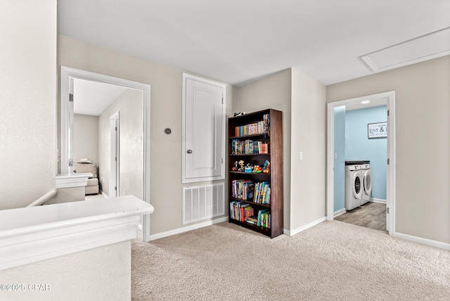 hall featuring visible vents, baseboards, carpet flooring, and washing machine and clothes dryer