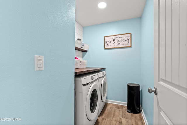 laundry room with baseboards, independent washer and dryer, wood finished floors, and laundry area