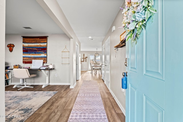 foyer entrance featuring visible vents, baseboards, and wood finished floors