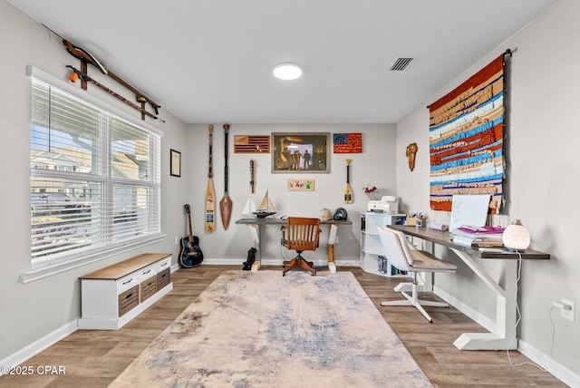 home office with visible vents, baseboards, and wood finished floors