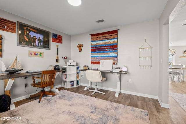 office space with wood finished floors, visible vents, and baseboards