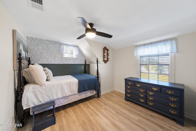 bedroom featuring visible vents, baseboards, lofted ceiling, ceiling fan, and light wood-style floors