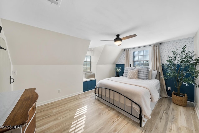 bedroom with baseboards, multiple windows, and light wood-style floors