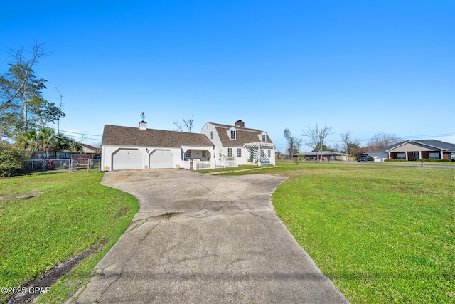 view of front of property featuring a chimney, concrete driveway, a front yard, and fence