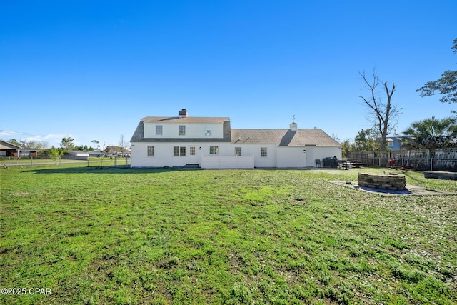 back of property featuring a lawn, a fire pit, and a fenced backyard