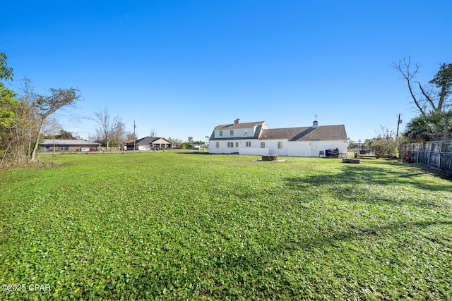 view of yard with a fire pit and fence