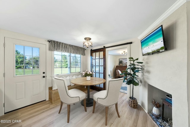 dining area with light wood-style flooring and a barn door