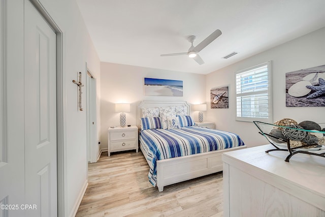 bedroom with visible vents, light wood-style flooring, baseboards, and a ceiling fan