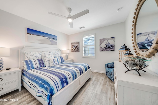 bedroom with a ceiling fan, light wood-style floors, visible vents, and baseboards