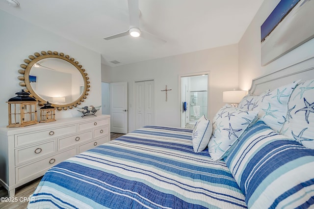 bedroom featuring a closet, ensuite bathroom, ceiling fan, and wood finished floors