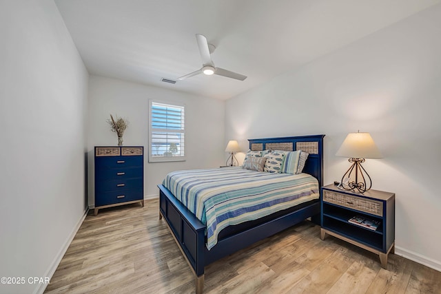 bedroom featuring visible vents, baseboards, light wood-style flooring, and a ceiling fan