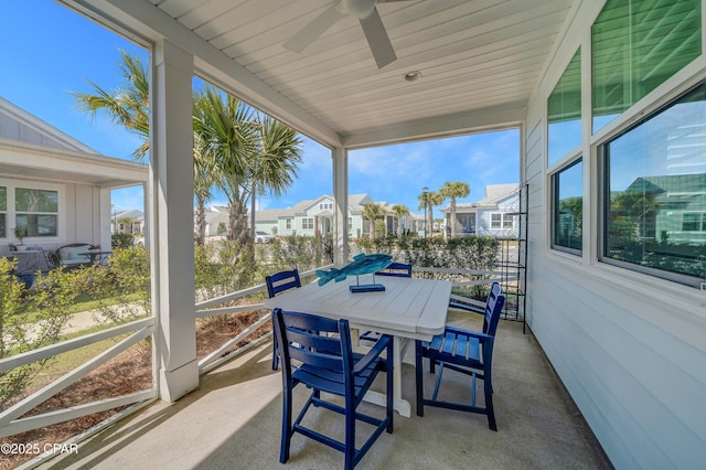 sunroom / solarium featuring a residential view and ceiling fan