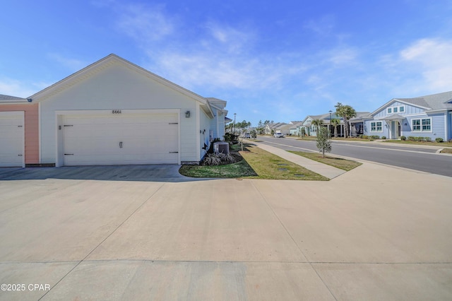 view of side of property with a residential view and driveway