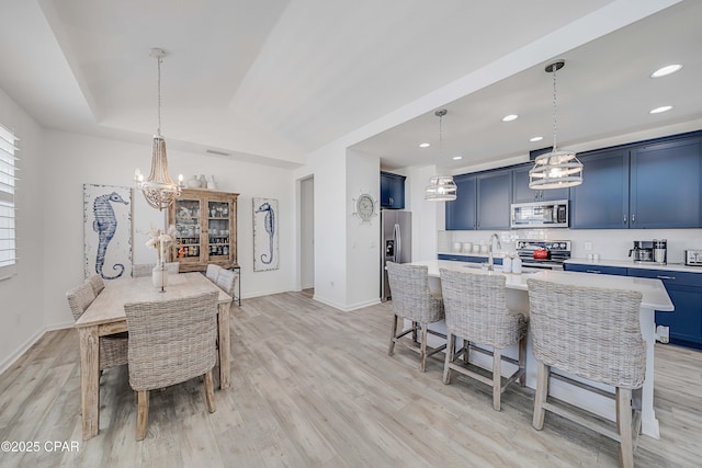 dining room featuring recessed lighting, baseboards, light wood-style floors, an inviting chandelier, and lofted ceiling