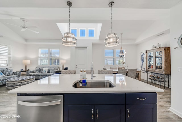 kitchen with stainless steel dishwasher, vaulted ceiling, open floor plan, and a sink