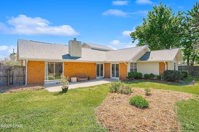 back of house featuring a yard, a patio, brick siding, and fence