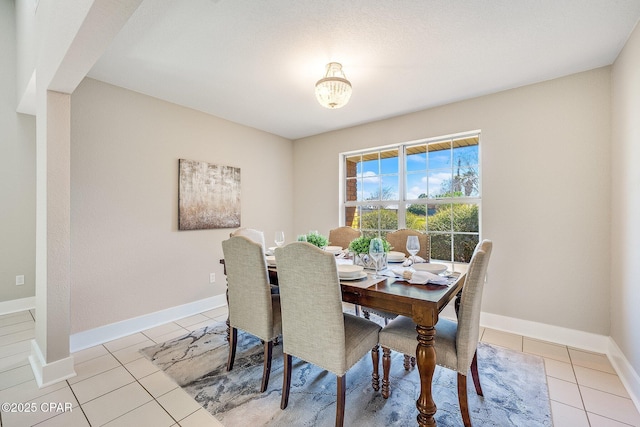 dining area featuring light tile patterned floors and baseboards