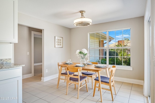 dining area with light tile patterned flooring and baseboards