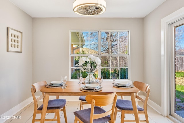 dining space featuring light tile patterned floors and baseboards