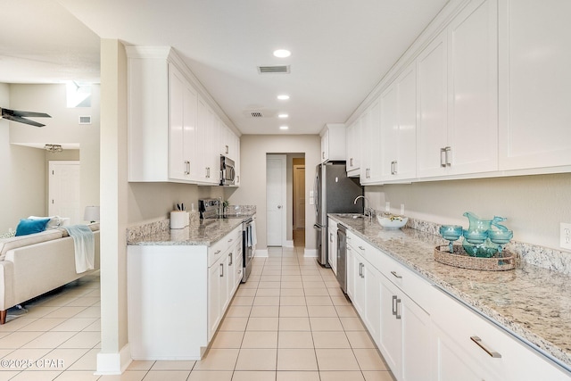 kitchen featuring visible vents, open floor plan, recessed lighting, white cabinets, and stainless steel appliances