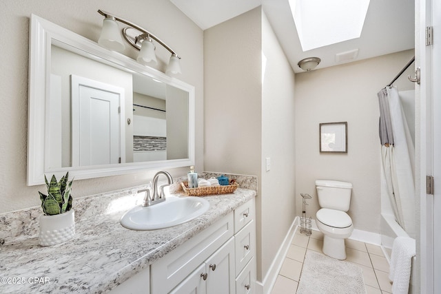 full bath with vanity, baseboards, a skylight, tile patterned floors, and toilet