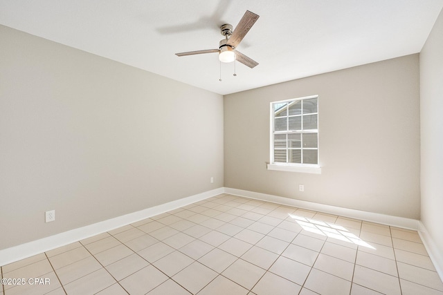 spare room featuring light tile patterned floors, baseboards, and ceiling fan