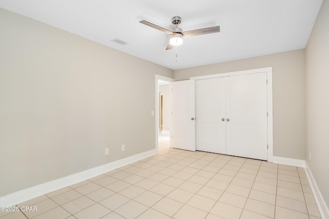 unfurnished bedroom featuring visible vents, baseboards, light tile patterned floors, a closet, and a ceiling fan