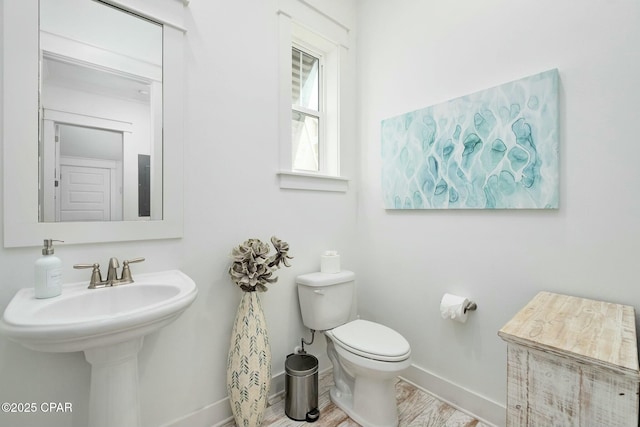 bathroom with baseboards and toilet