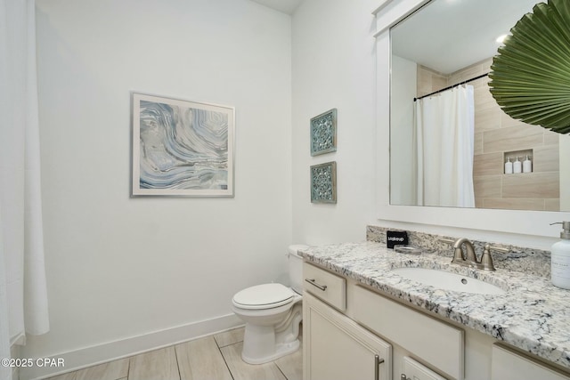 bathroom featuring vanity, toilet, a shower with curtain, and baseboards