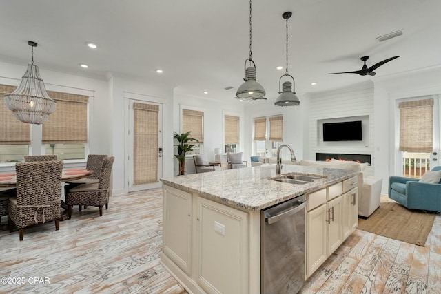 kitchen with stainless steel dishwasher, light wood-style floors, a sink, visible vents, and open floor plan