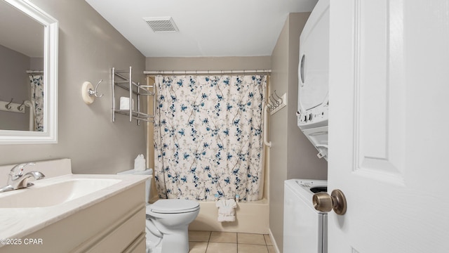 bathroom with vanity, visible vents, stacked washer and clothes dryer, tile patterned floors, and toilet